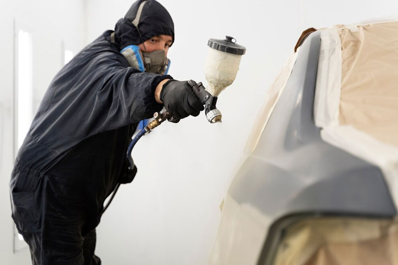 A car being painted with a fresh coat of high-quality automotive paint, showcasing a smooth and glossy finish in a professional car painting service